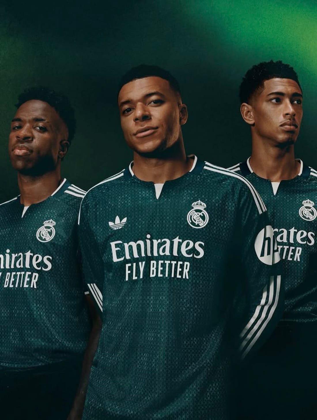 Trois footballeurs en maillots verts, lumière de studio sombre