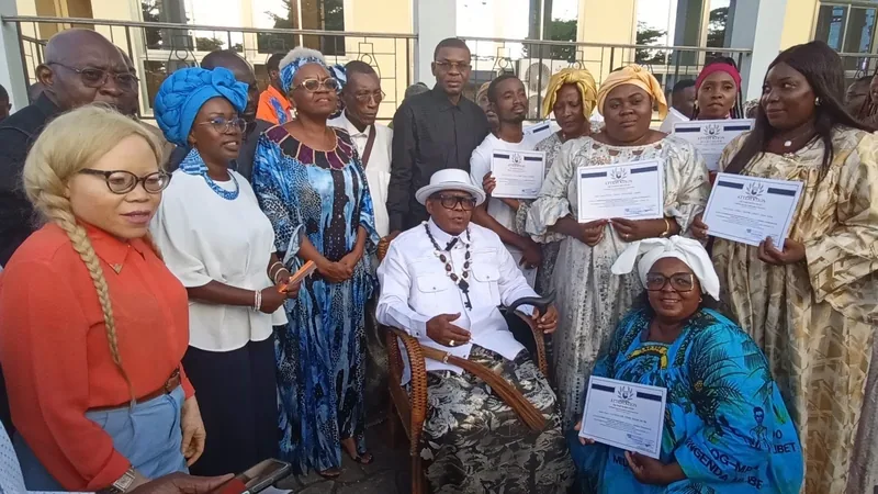 Des participantes montrent leur attestation, autour d’un notable assis