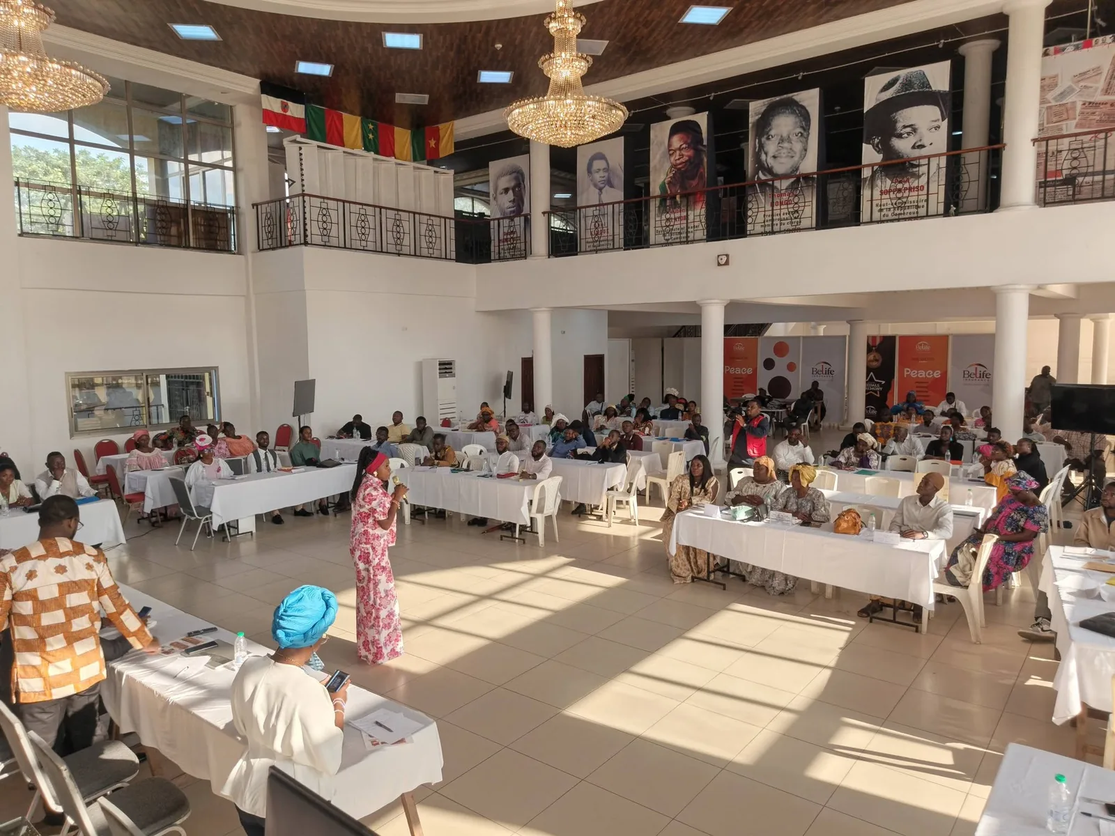 La grande salle du Palais de la Culture Sawa pendant les ateliers, des participants assis autour des tables